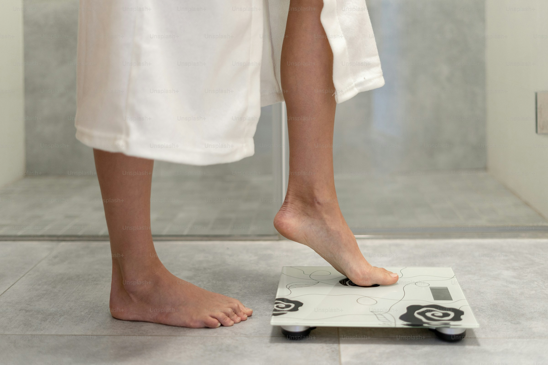 Woman stepping onto a bathroom scale